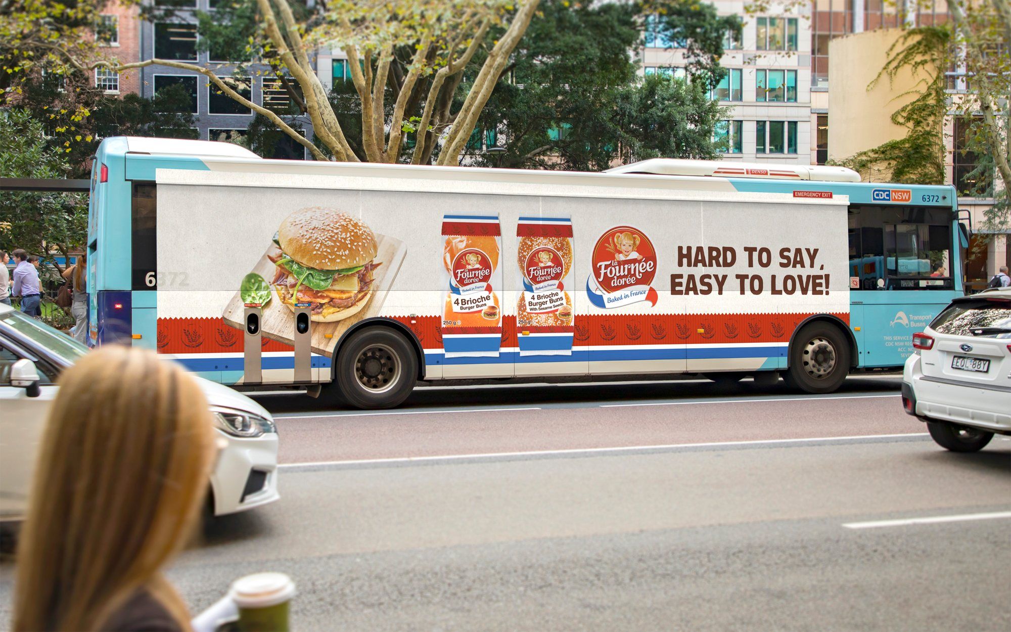 Fournée Dorée bus side advertisement passing on a city street